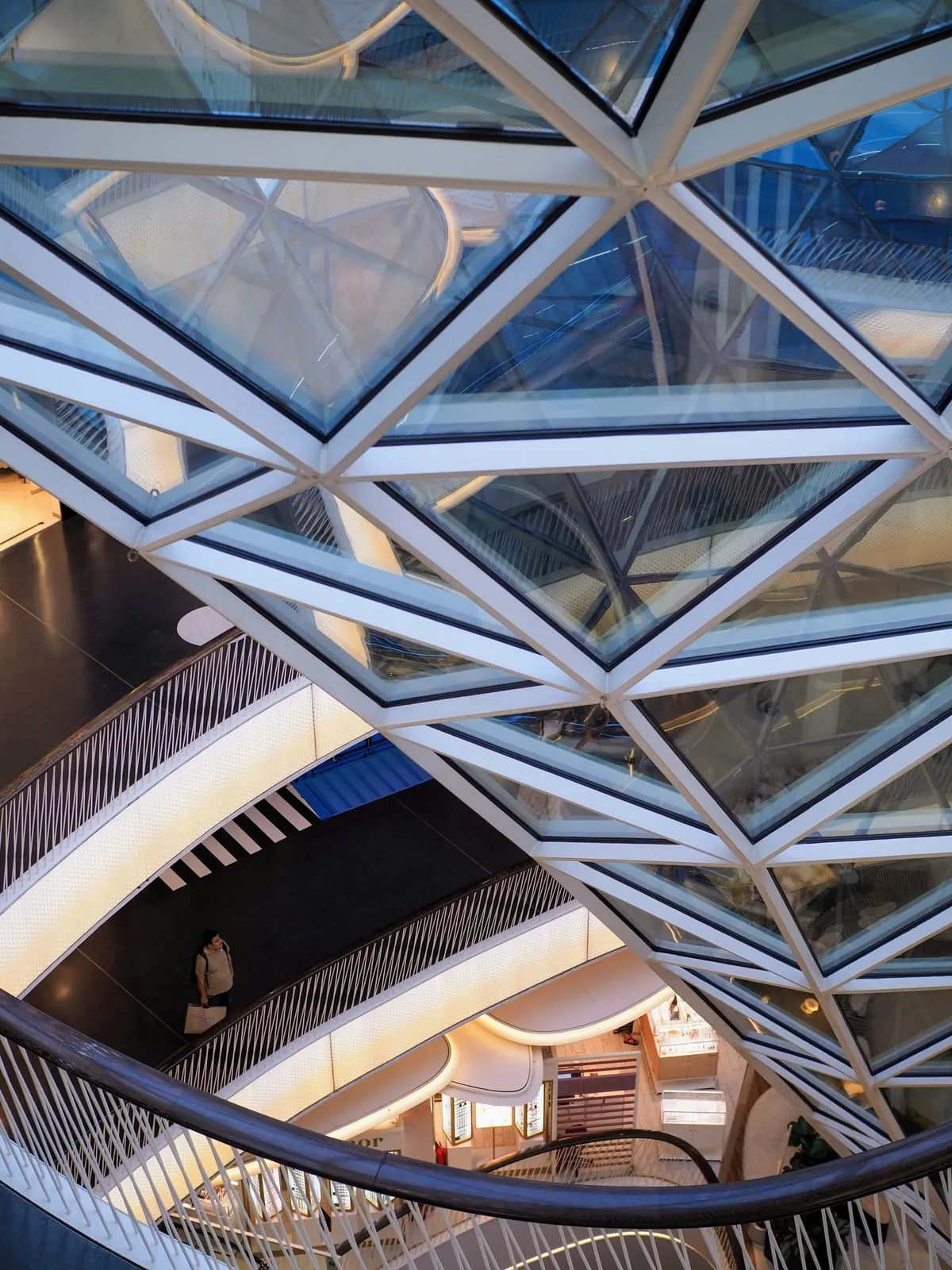 Glass roof lattice over curved shopping floors, 2024