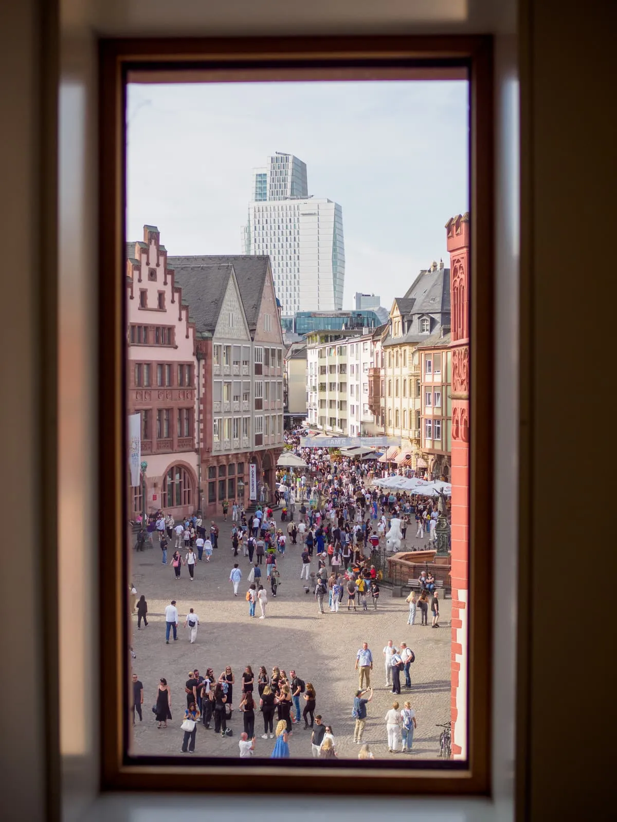 Window framing an old town square and towers behind, 2026, Frankfurt am Main