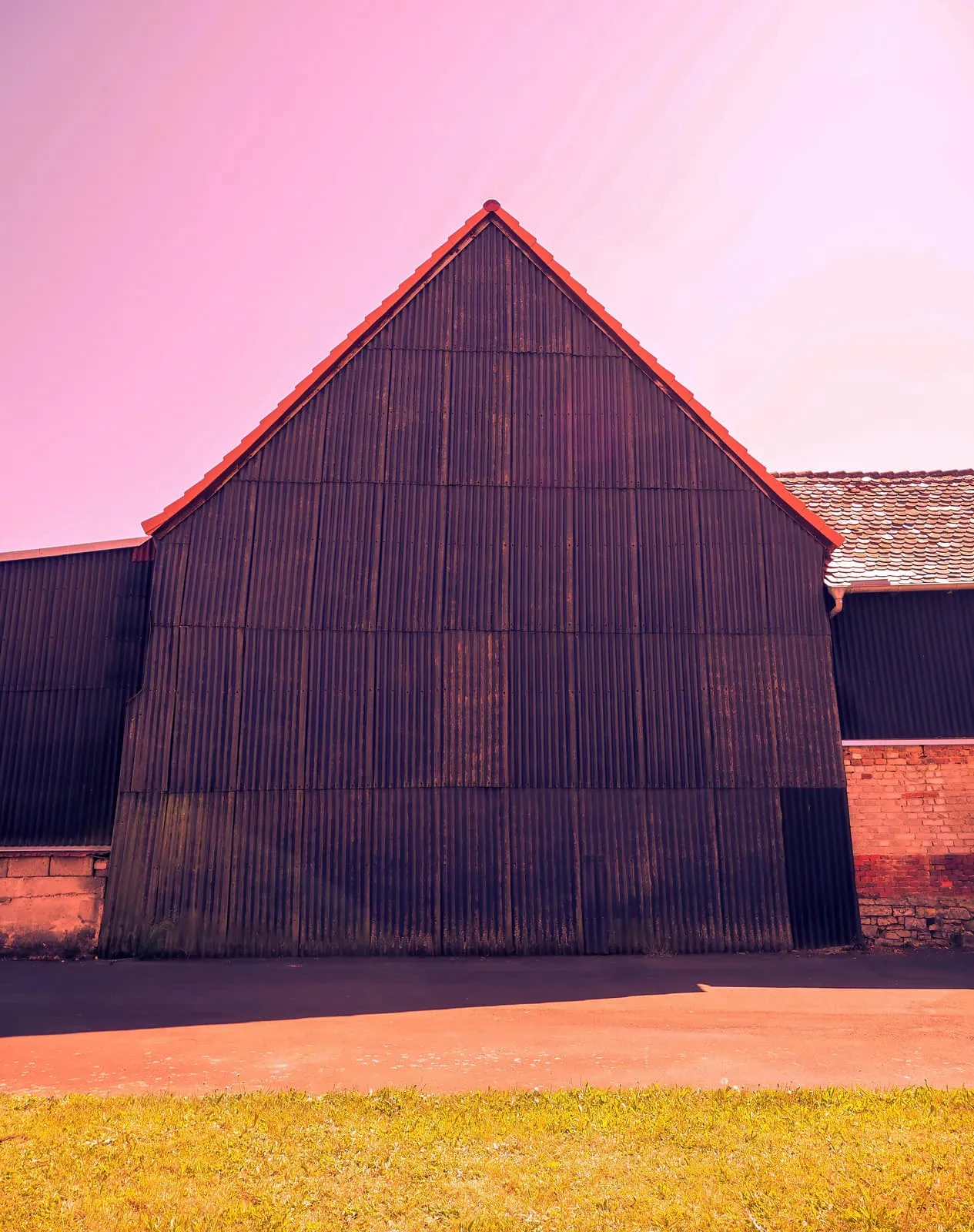 Dark barn gable under a pink sky, 2020