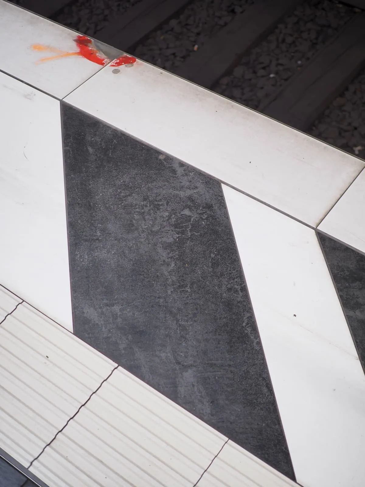 Black and white tile pattern at a platform edge, 2026