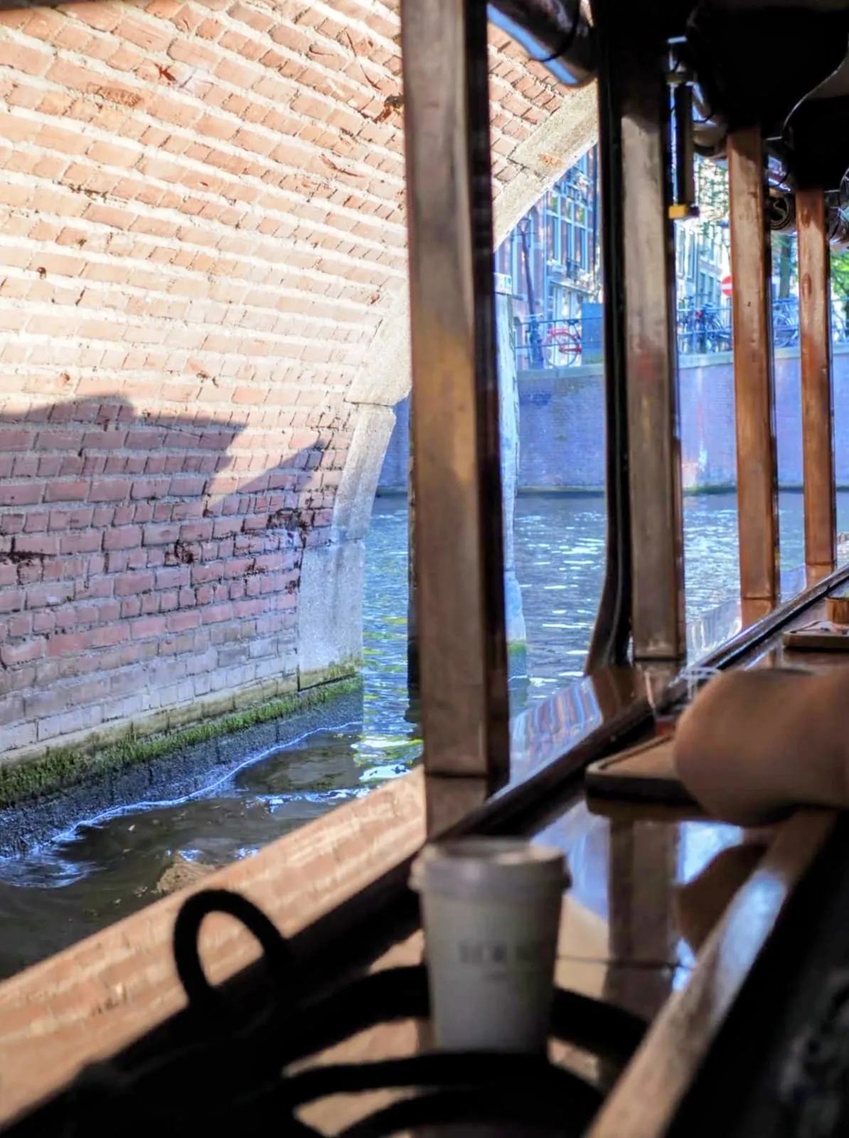 Boat cabin under a brick arch, a paper cup on the ledge, 2024