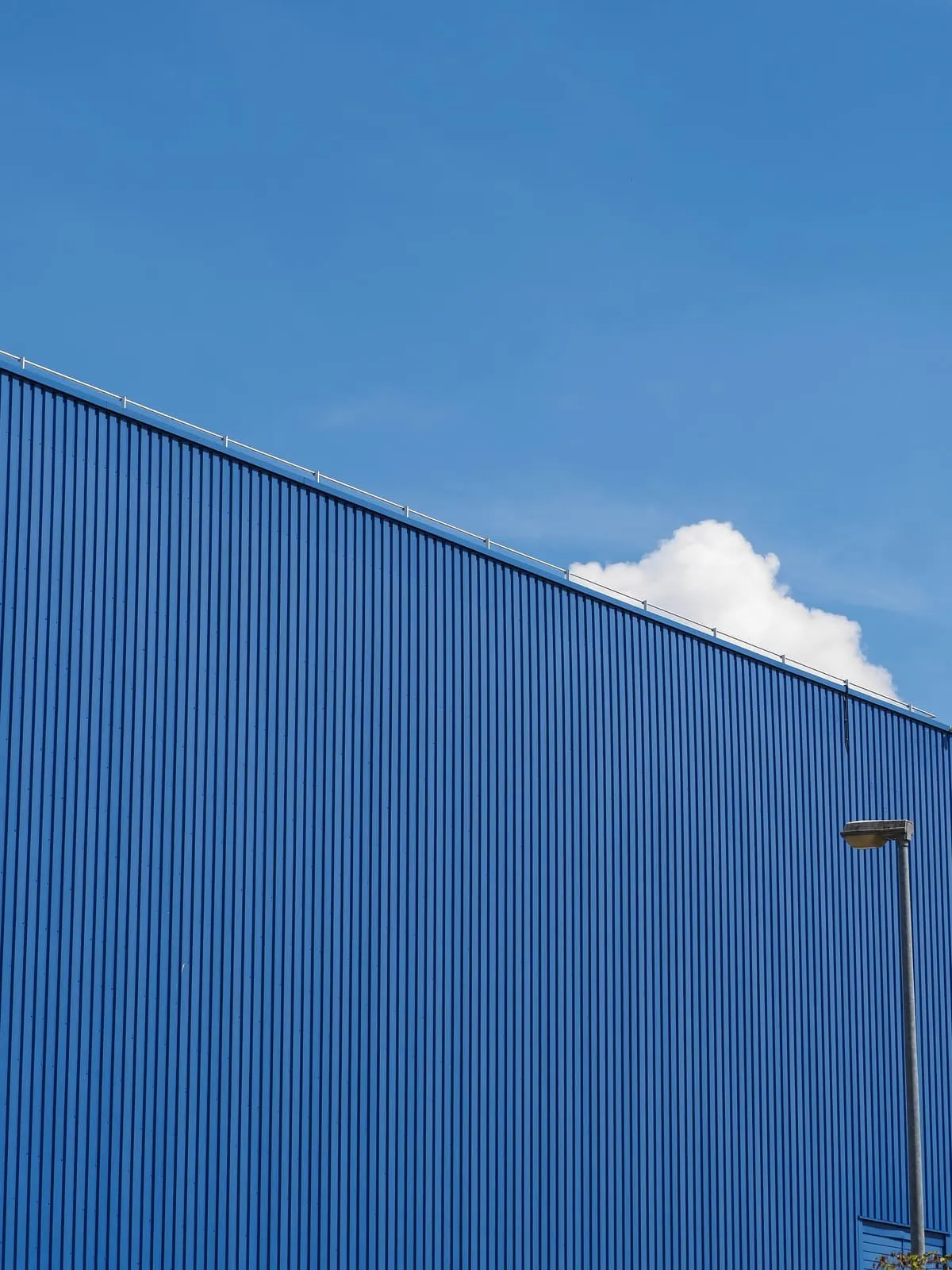 The same blue wall at an angle, with a cloud, 2020