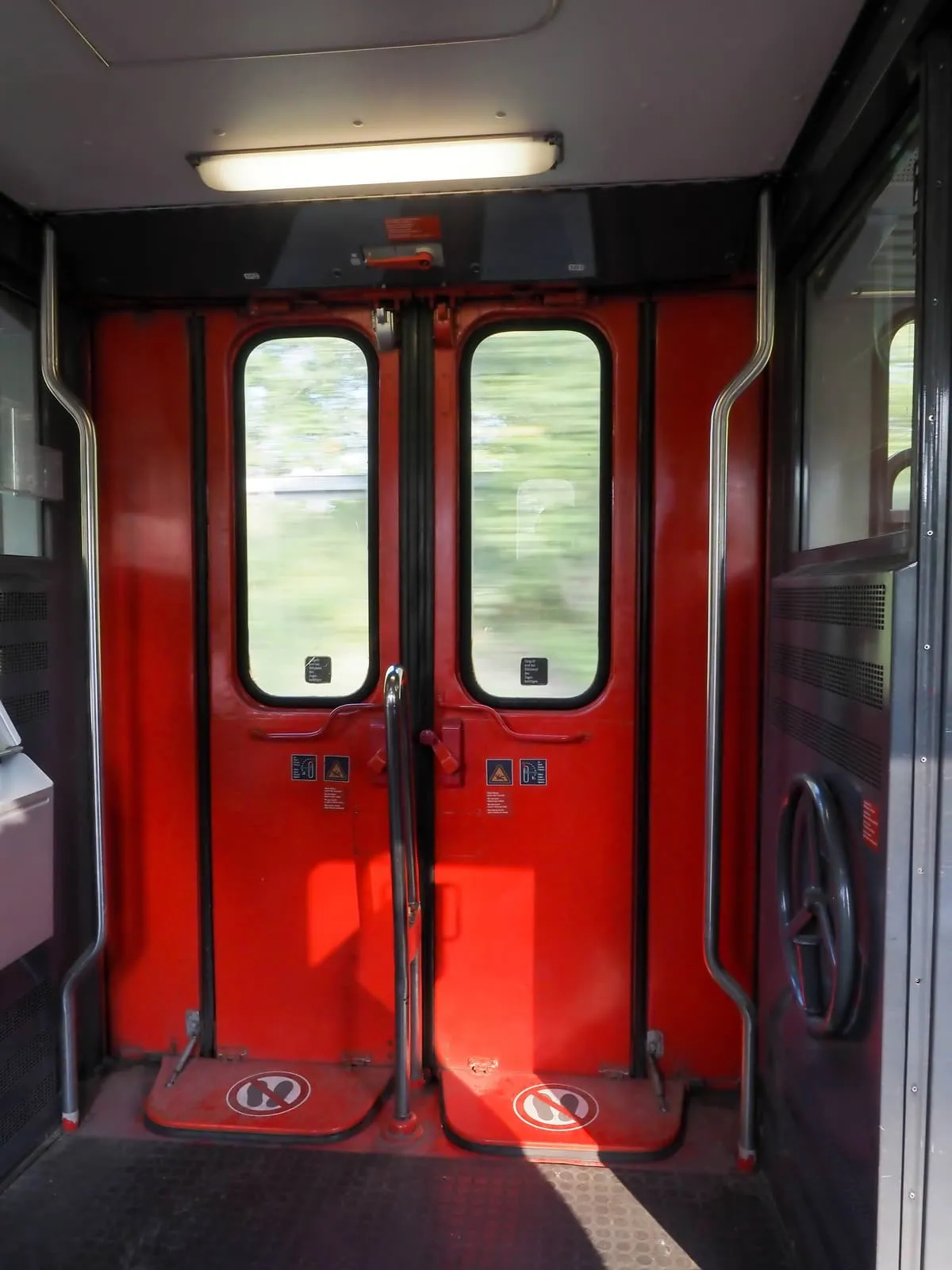 Red train doors seen from inside the carriage, 2020