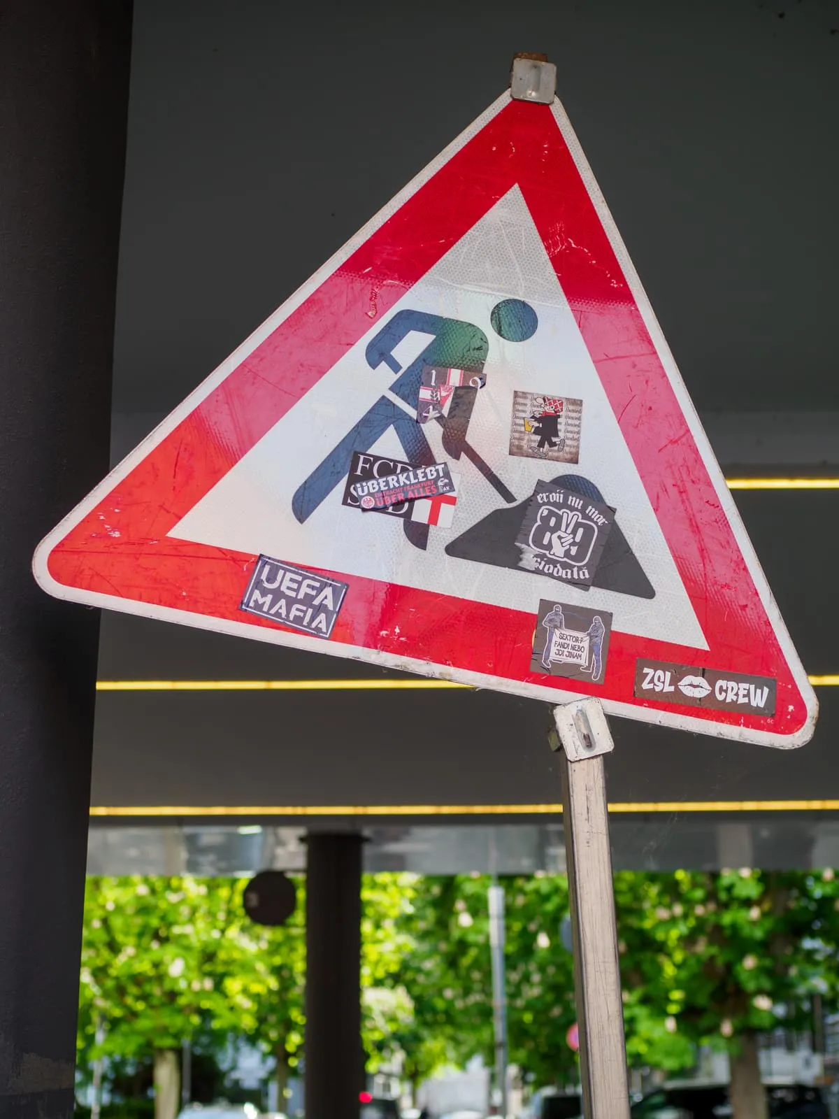 Roadworks warning sign covered in football stickers, 2026