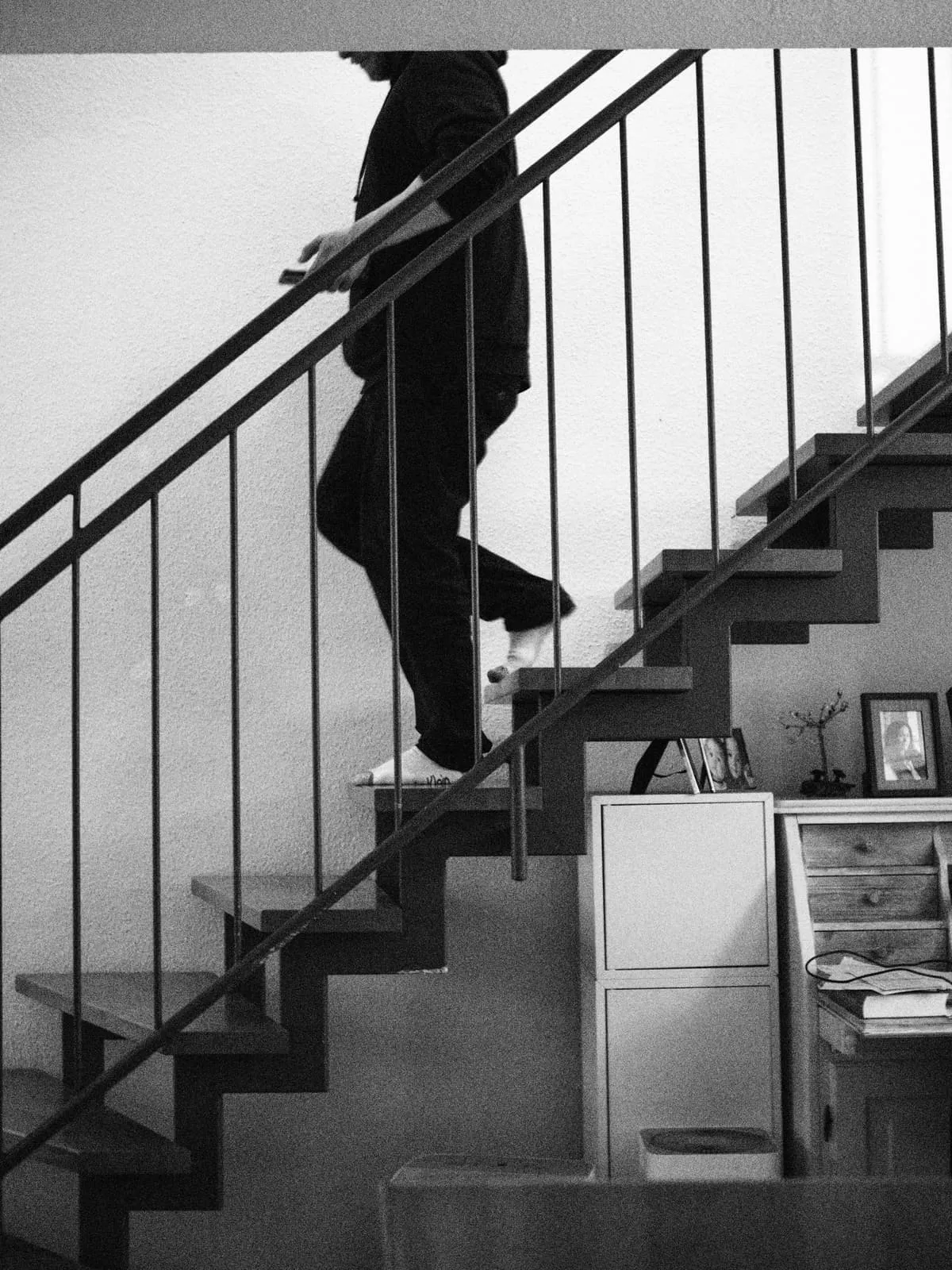 Black and white legs on an open staircase, 2024