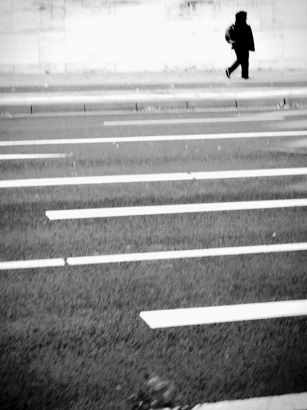 Black and white road markings, a small figure walking at the top, 2021