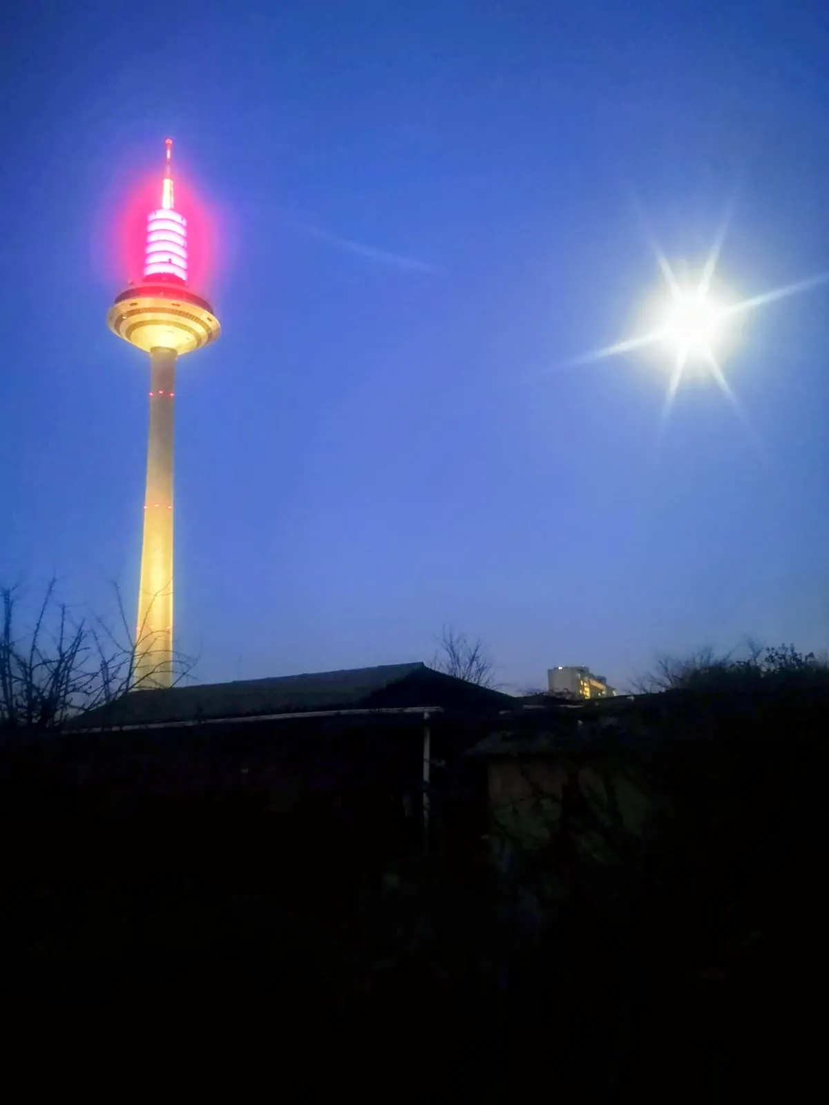 Tower lit pink at night beside a bright moon, 2021, Frankfurt am Main