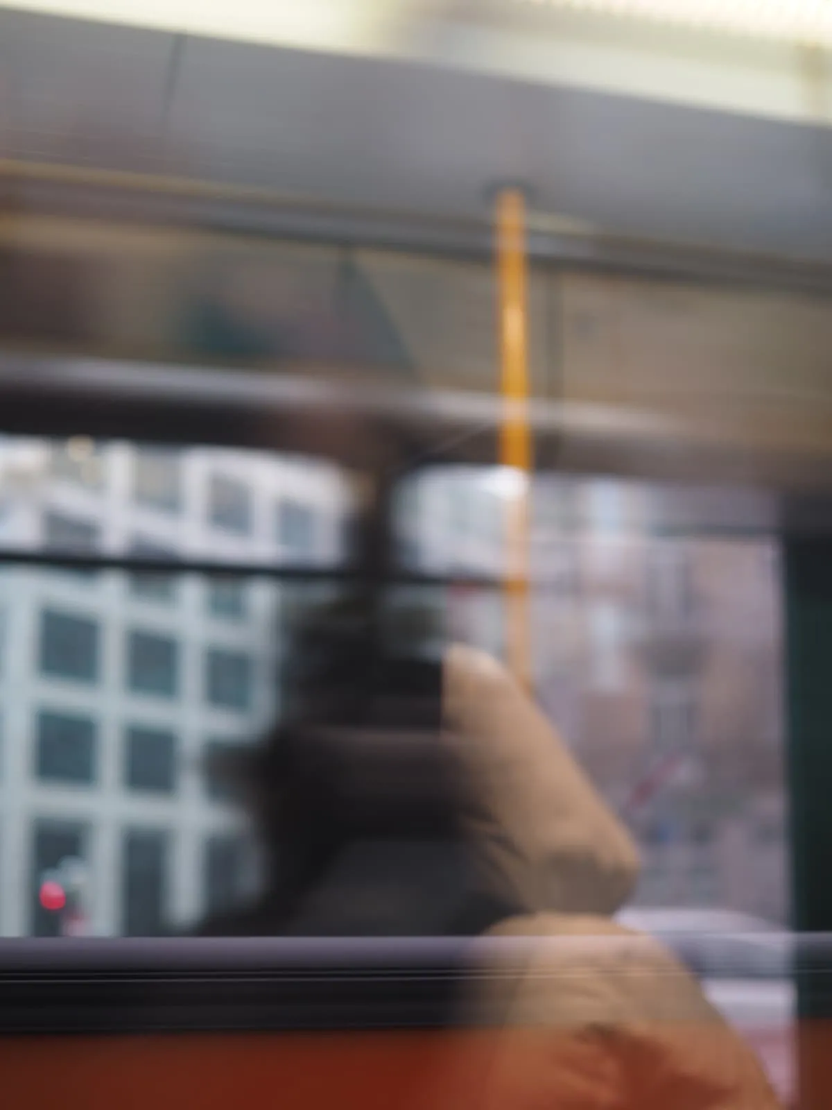 Blurred figure seen through a moving tram window, 2026