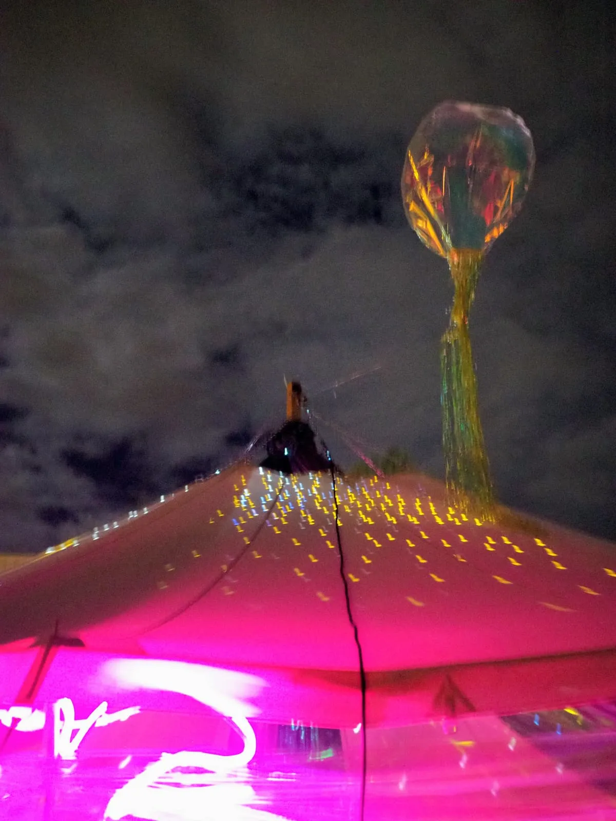 Pink tent roof at night under a glowing balloon, 2026