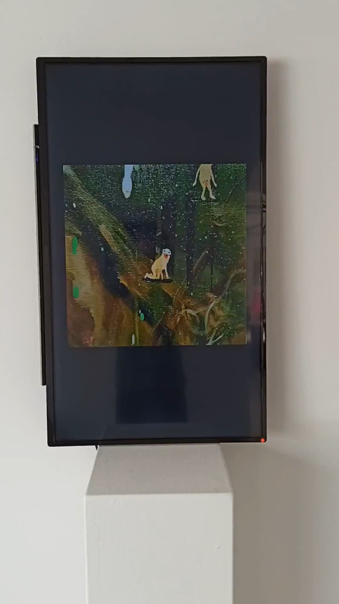 Eine bildschirmbasierte Arbeit mit kleinen Figuren und Tieren vor einer dunkelgrünen Landschaft